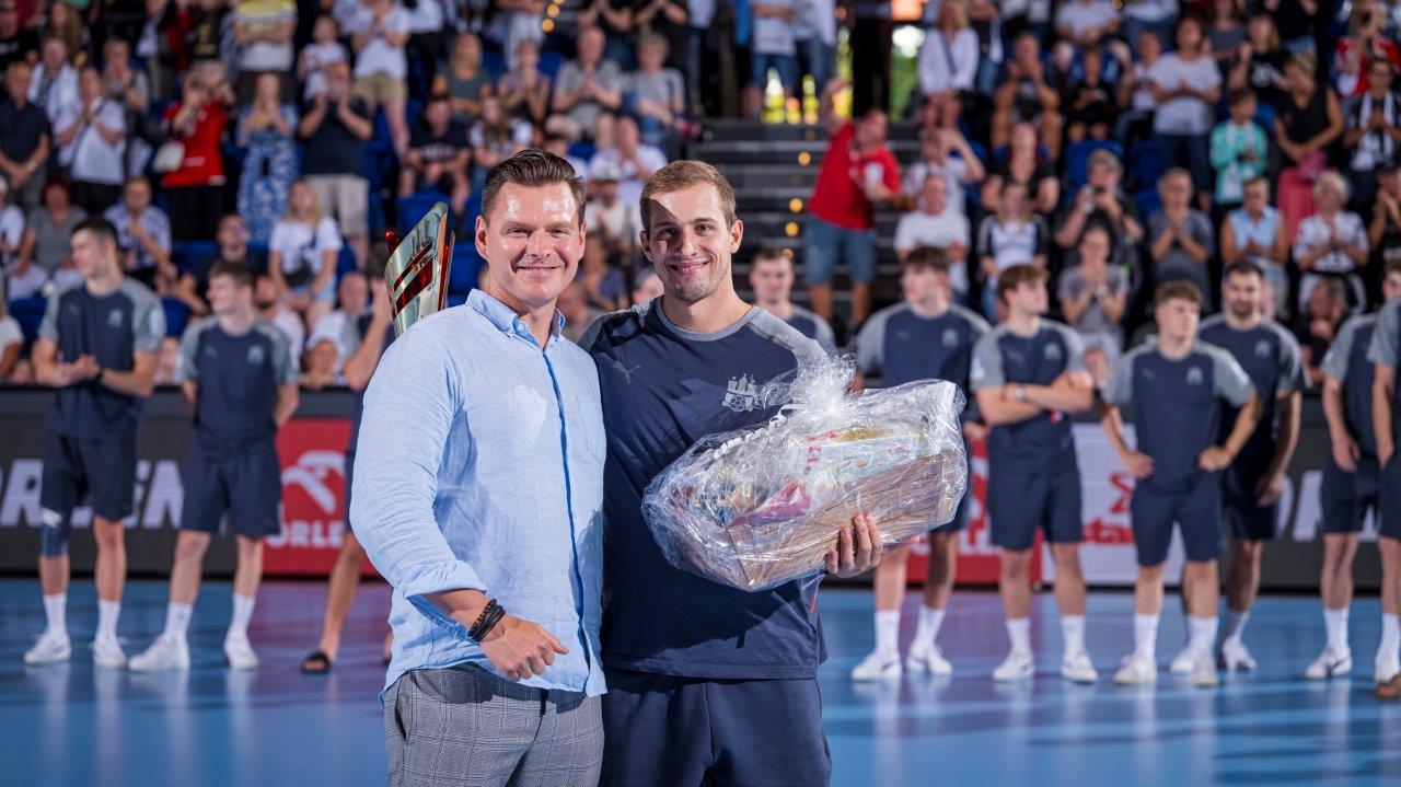 ORLEN Deutschland CEO Jaroslaw Marczak überreicht den Siegerpokal an HSV Handball-Kapitän Niklas Weller .jpg